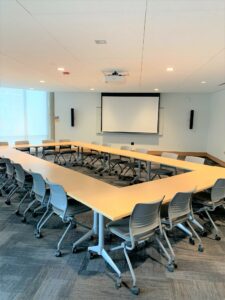 Room 104 with tables arranged into a hollow rectangle shape.